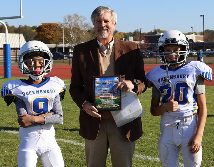Mister Strough handing out an award to 2 young football players